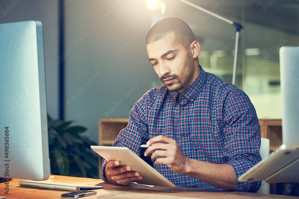 Working on the last few final touches to his project. Cropped shot of a young designer working late 