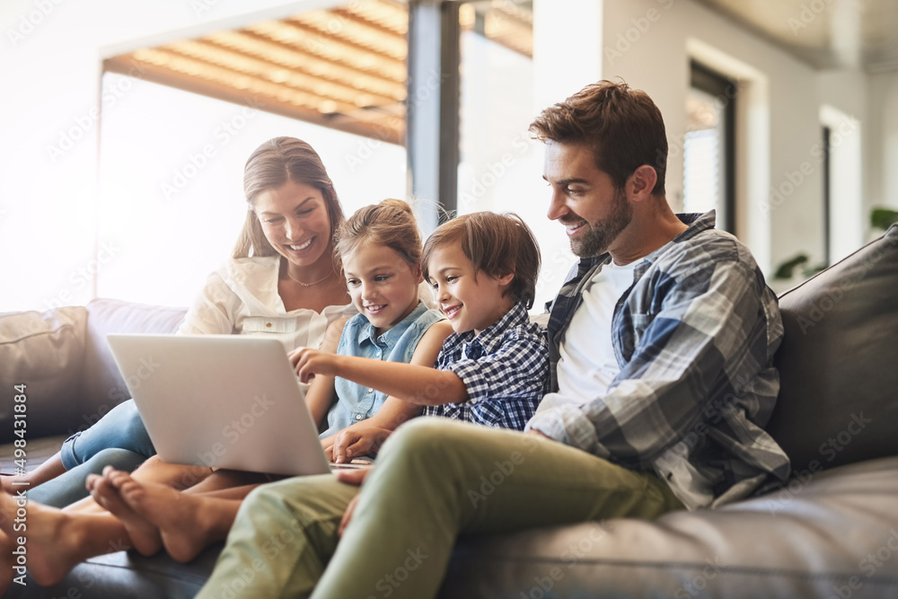 Connected online and as a family. Shot of a mother and father using a laptop with their son and daug