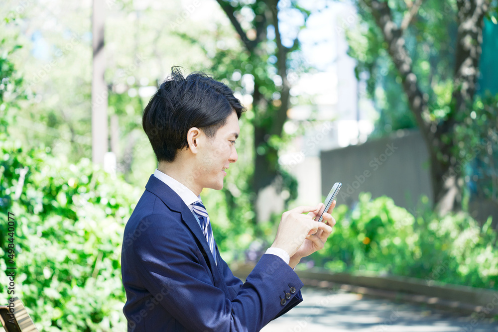 ビジネスマン　スマホ　屋外