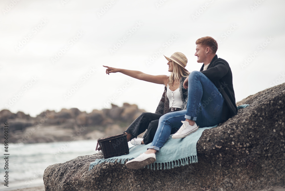 A date on the beach is all it takes to win my heart. Shot of a man taking pictures of his girlfriend