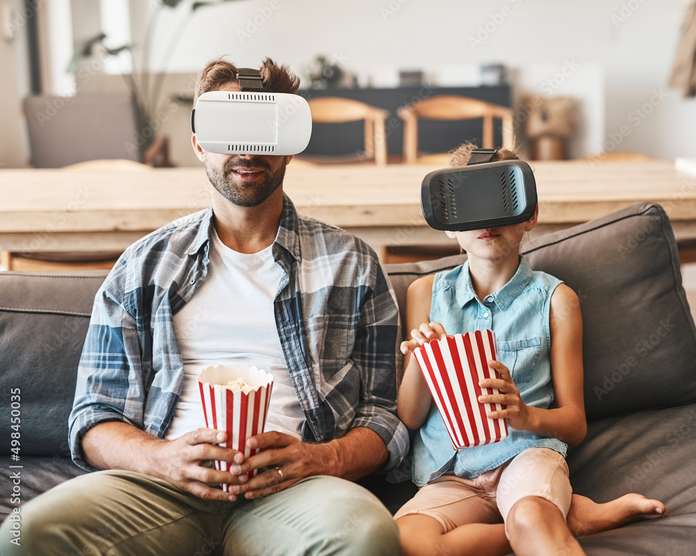 Taking movie night to the next level. Shot of a father and daughter eating popcorn and watching movi