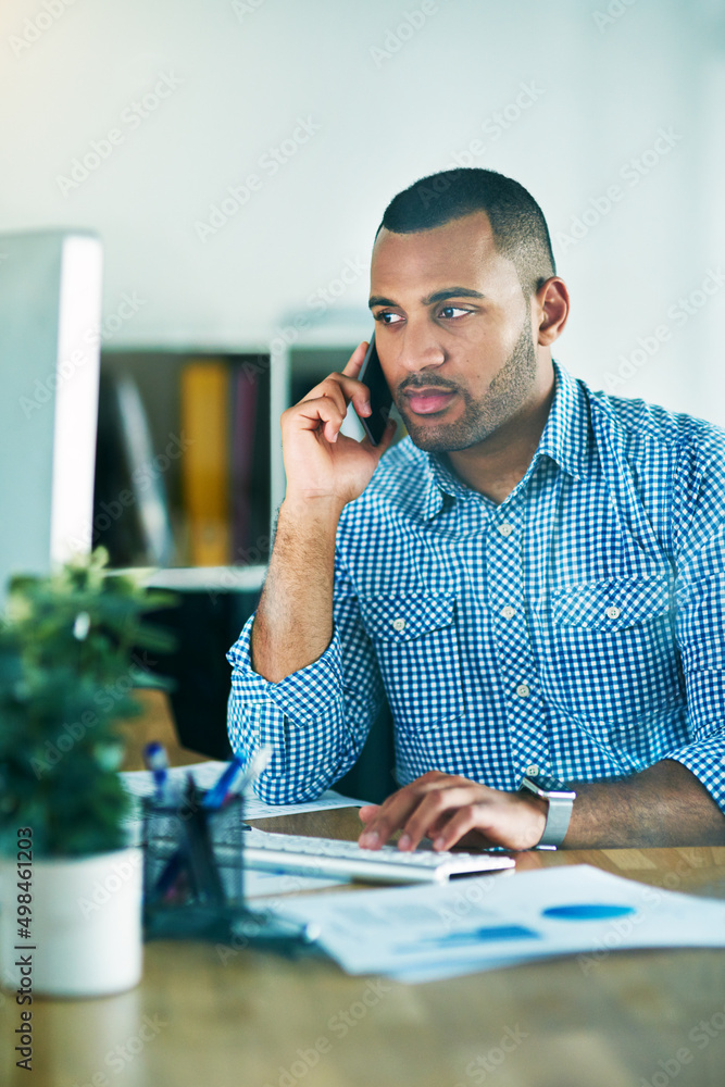 Im sending you an email.... Shot of a handsome young businessman making a phonecall while working in