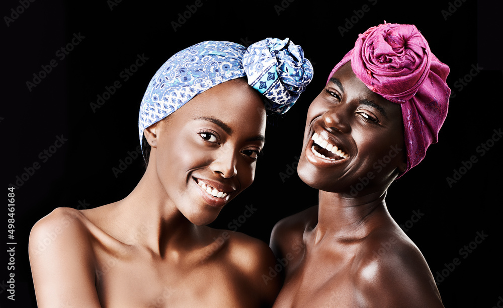 Friends in fashion. Studio portrait of two beautiful women wearing headscarves against a black backg