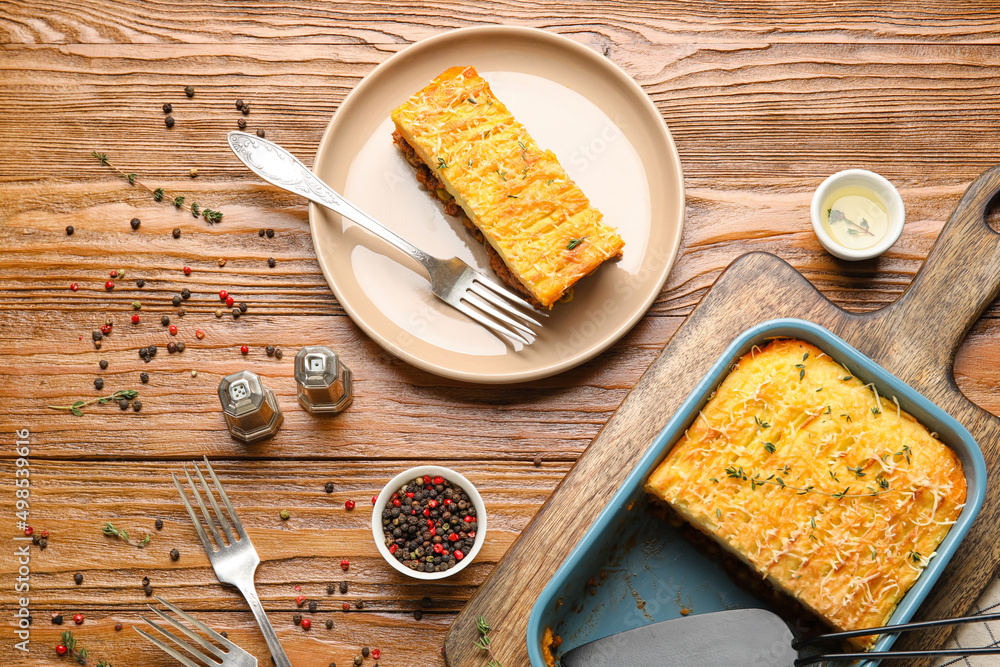 Plate with piece of tasty Shepherds pie on wooden background