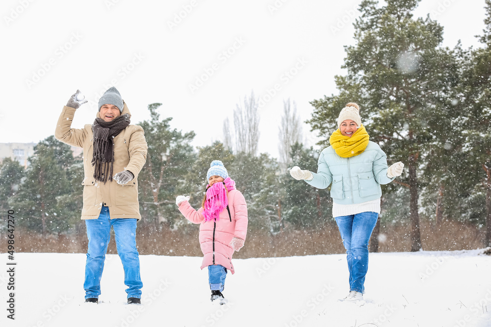 小女孩和她的爷爷奶奶在下雪的冬日扔雪球