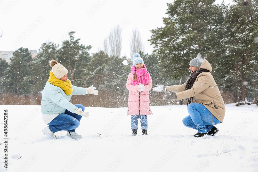 小女孩和她的爷爷奶奶在下雪的冬日扔雪球