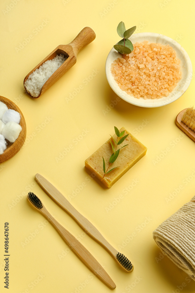 Set of bath supplies with soap bar on color background