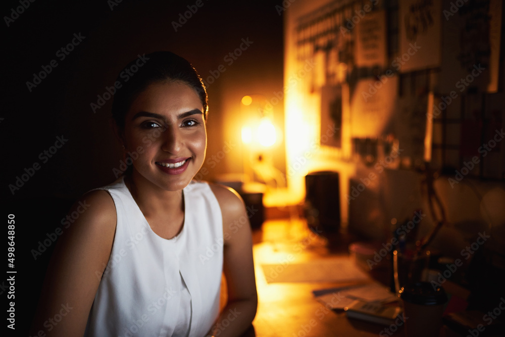 Its never too late to reach for more success. Portrait of a young businesswoman working late in an o