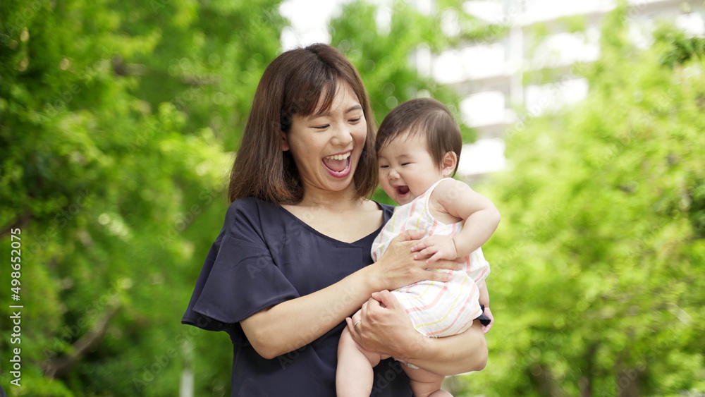 公園を散歩する赤ちゃんとお母さん