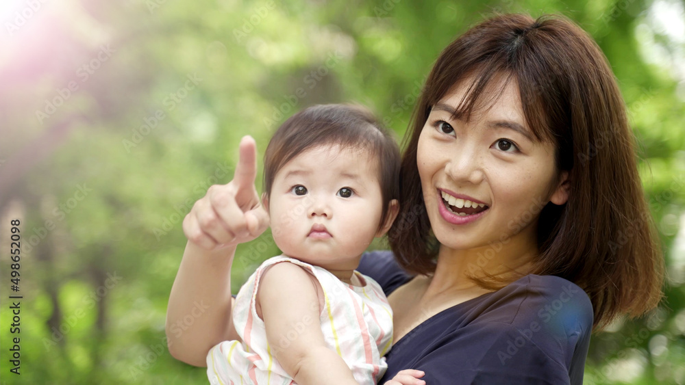 公園を散歩する赤ちゃんとお母さん