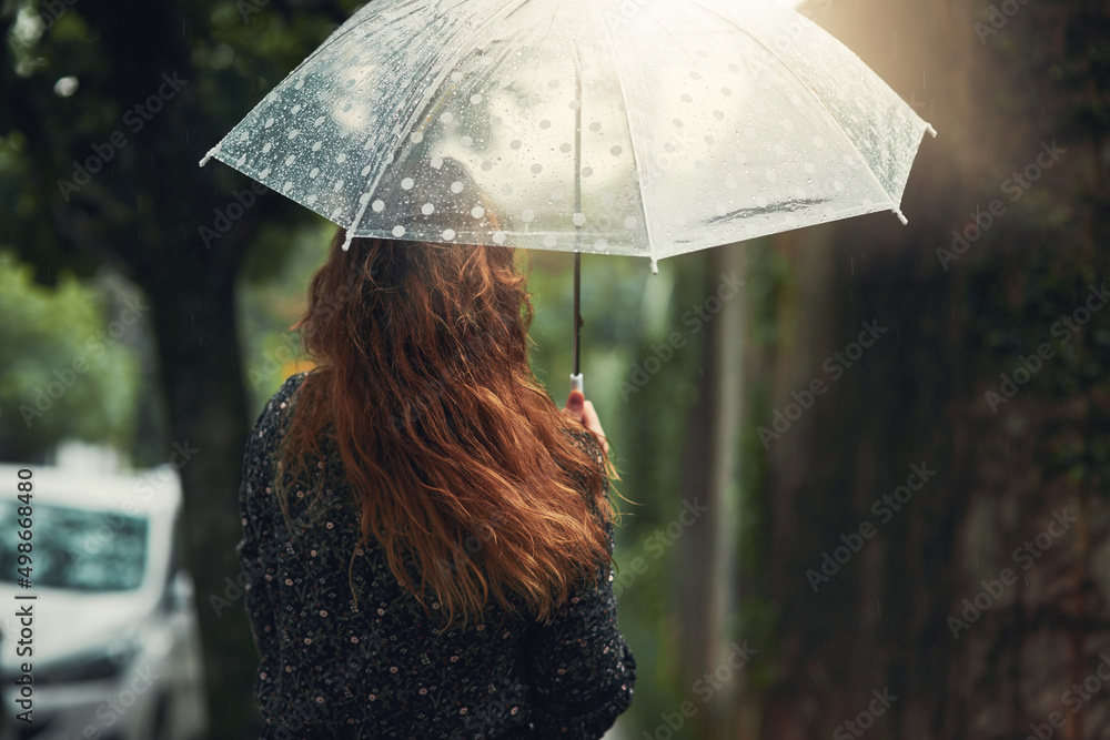 让雨水冲走昨天所有的烦恼。一个面目全非的女人走着的后视镜头