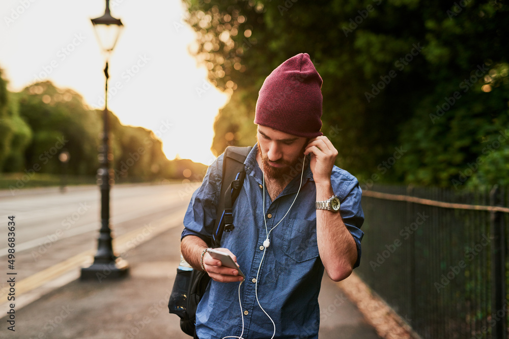 He needed a dope beat to step to. Cropped shot of a handsome young man listening to music on his cel