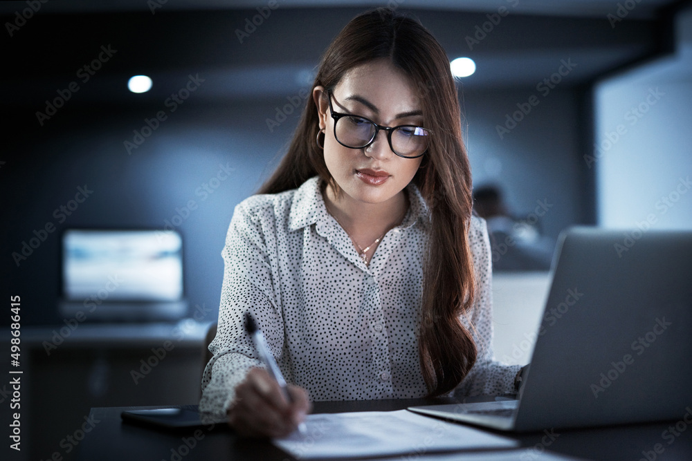 She wont leave until her paperwork is all in order. Shot of a young businesswoman going through pape