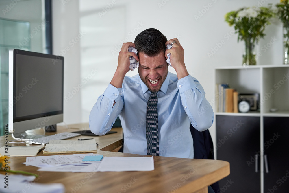 When will I see an end to these deadlines. Shot of a young businessman looking stressed out while wo