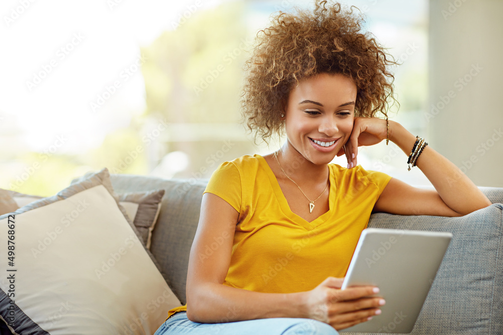 Her favourite online magazine keeps her entertained for hours. Shot of a young woman using a digital