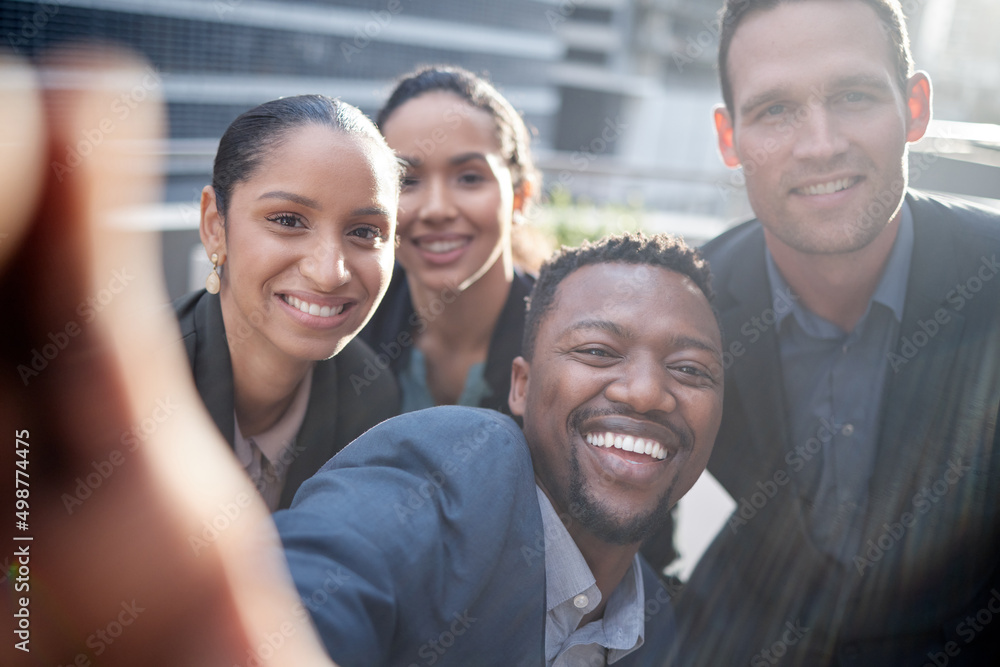 Sometimes you just need to take a selfie. Shot of a group of businesspeople taking a selfie against 