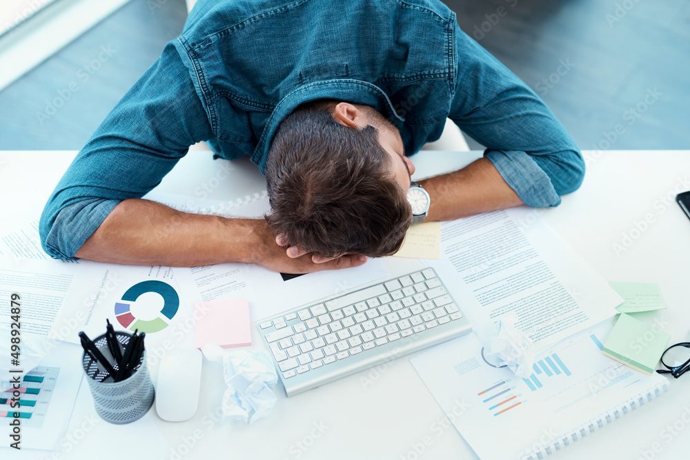 Even he needs to refresh every now and then. High angle shot of an exhausted young businessman takin