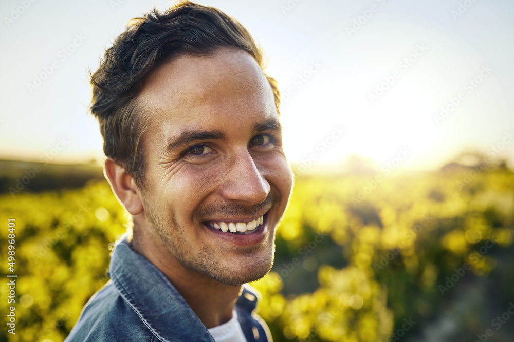 Its the season for some pickin. Portrait of a happy young man working on a farm.