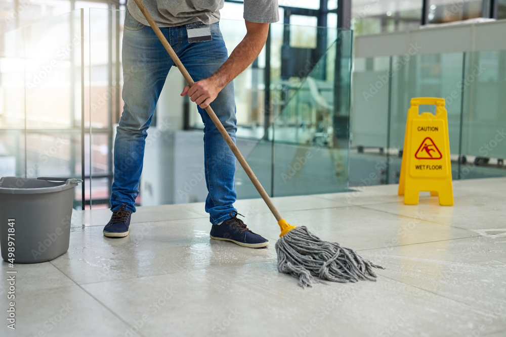 Hell leave that floor spotless. Shot of an unrecognizable man mopping the office floor.