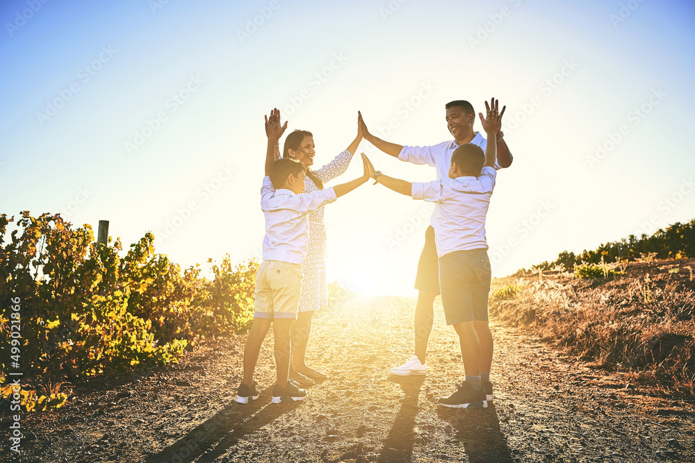 High five for some fun family times. Shot of a happy family high fiving together outdoors.