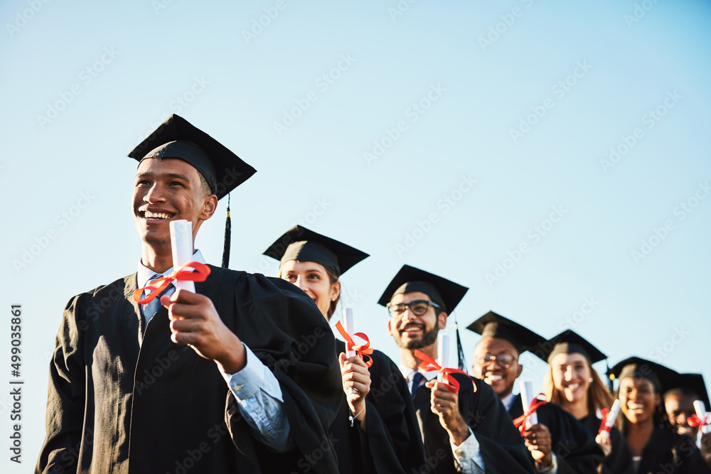 成为你想看到的改变。一名面带微笑的大学生在毕业典礼上与同学合影