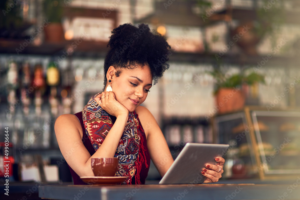 Browsing through her social media feeds. Cropped shot of an attractive young woman using a digital t