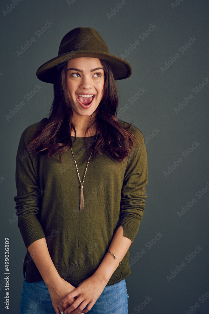 I didnt do anything. Studio shot of a carefree young woman posing with a hat while standing against 