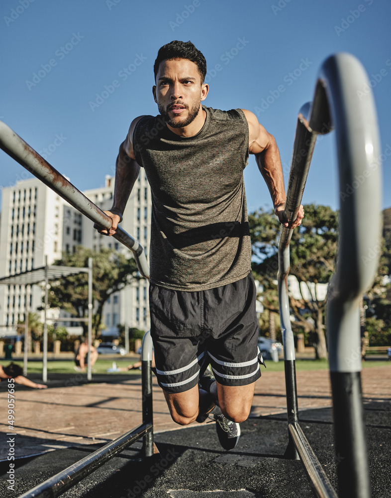 A little effort goes a long way. Shot of a muscular young man exercising at a calisthenics park.