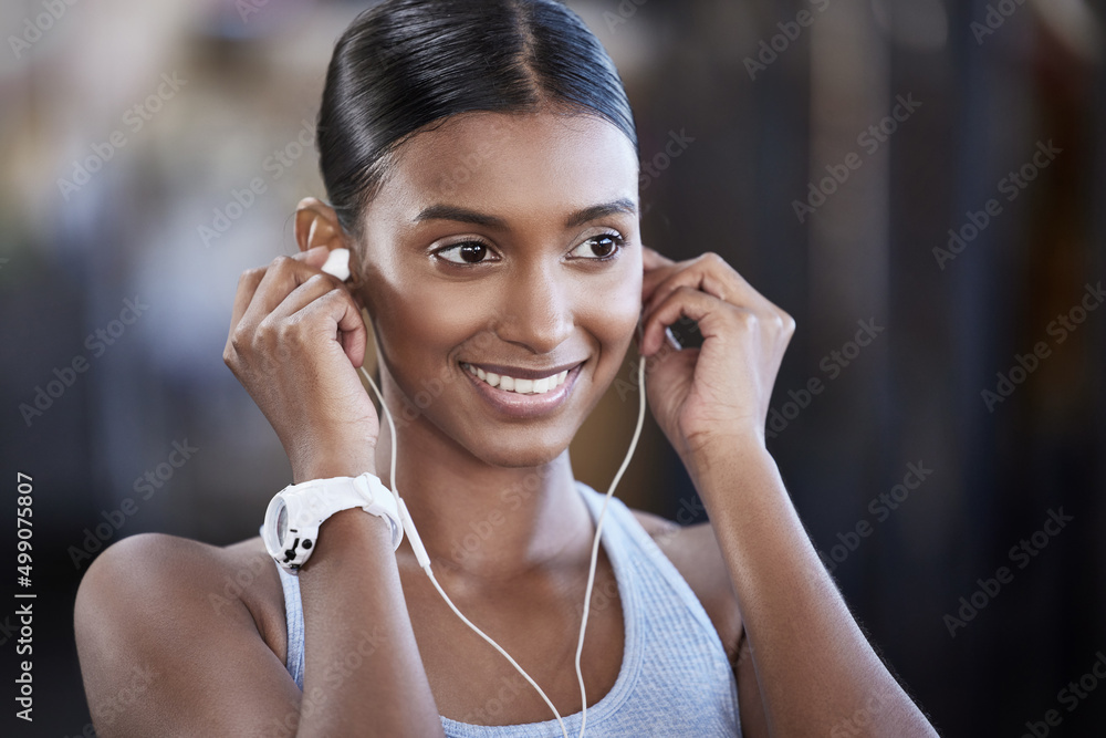 Ready to get started on the best workout today. Shot of a sporty young woman listening to music whil