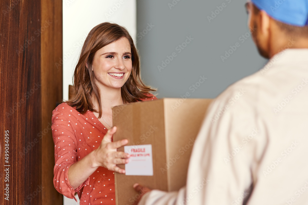 Thank you. Cropped shot of a young woman receiving her package from postal worker.