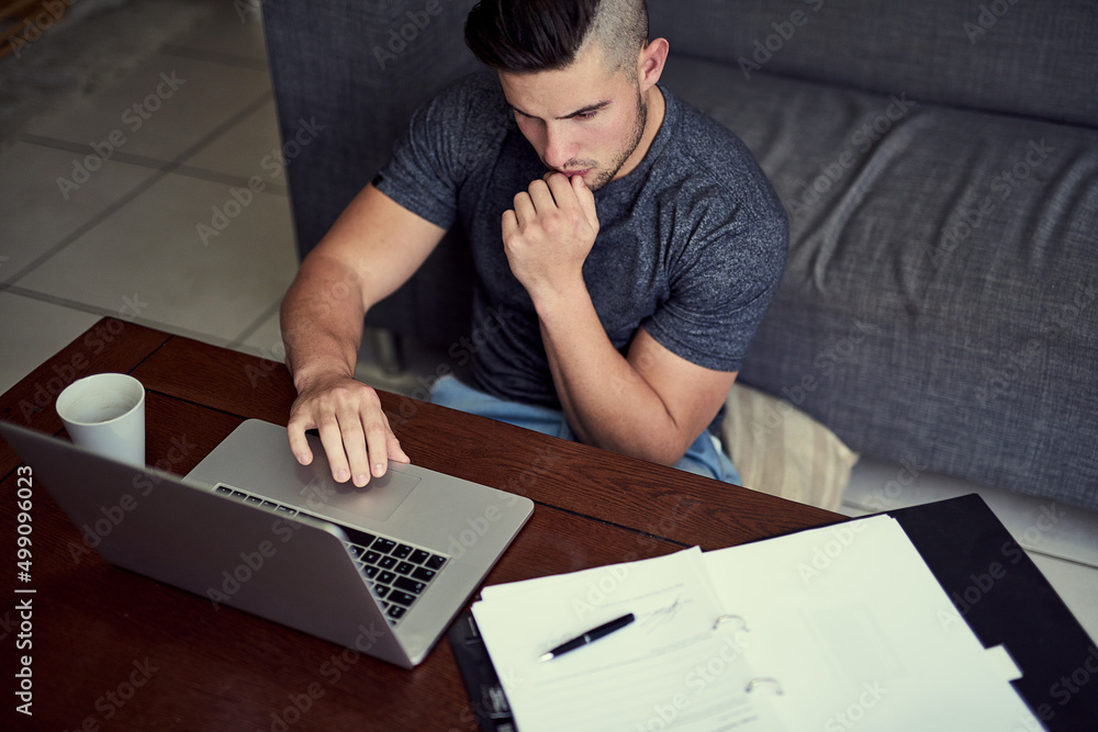 Hes got the discipline to work from home. Shot of a driven young man using his laptop to work from h