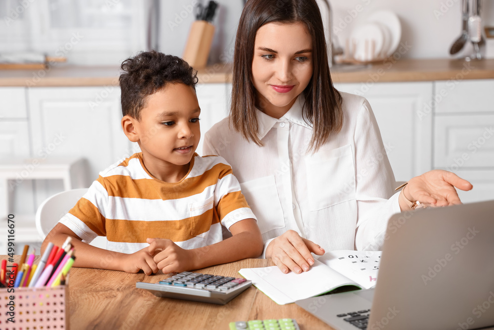 Little African-American boy studying with tutor at home