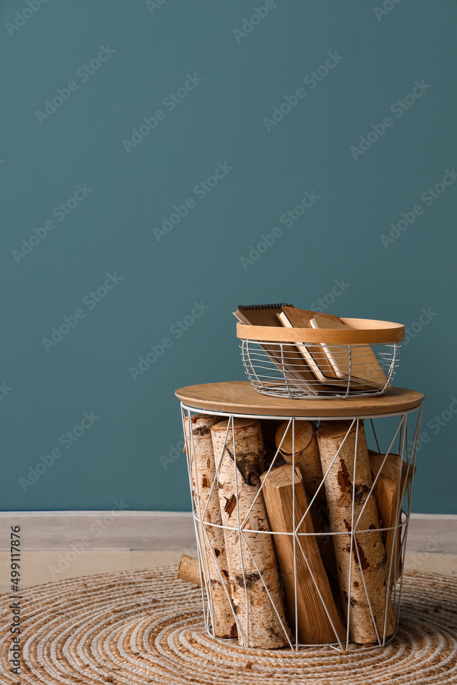 Basket with books on table near color wall in room