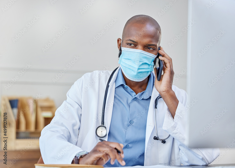 He can listen to your health needs. Shot of a young doctor on a call while writing in a notebook at 