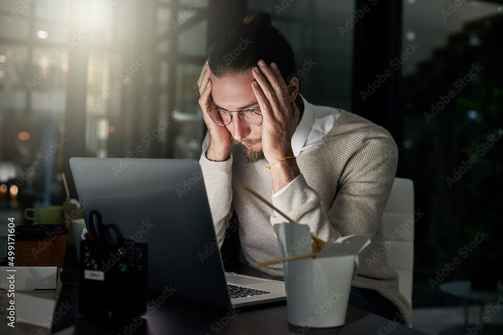 These late nights are causing him much stress. Cropped shot of a young designer looking stressed whi