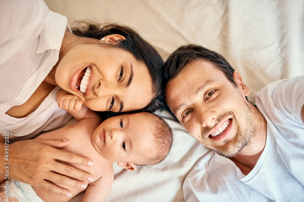 50 mommy, 50 daddy = 100 cute. High angle shot of a happy mother and father taking selfies with thei