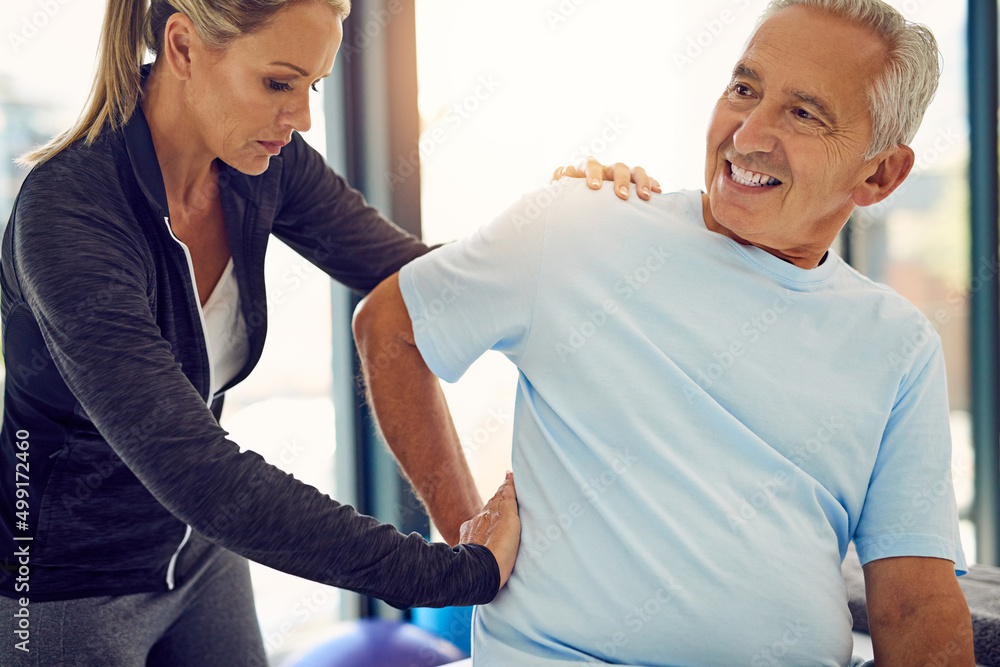 Applying pressure to ease the pain. Shot of a physiotherapist examining a senior patient with back p