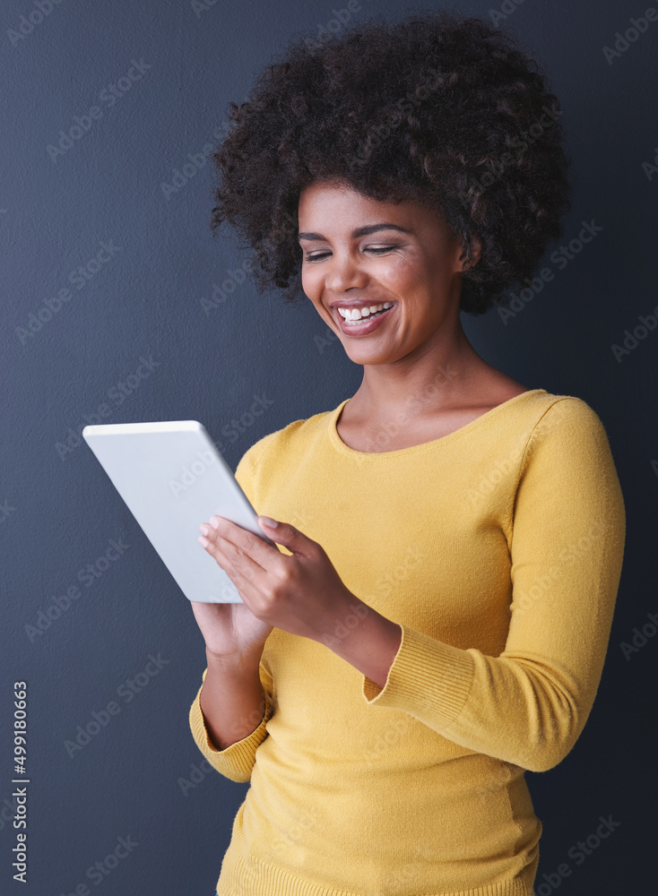 The possibilities are endless. Studio shot of a young woman using her tablet against a grey backgrou