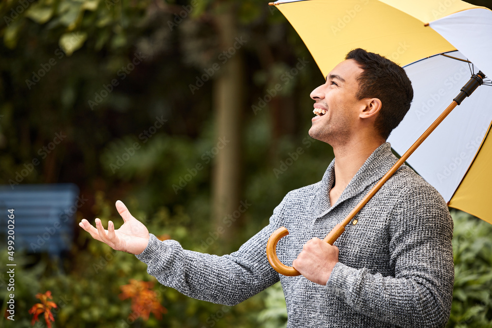 下雨的时候，倾盆大雨。一个年轻人撑着伞站在雨中的镜头。