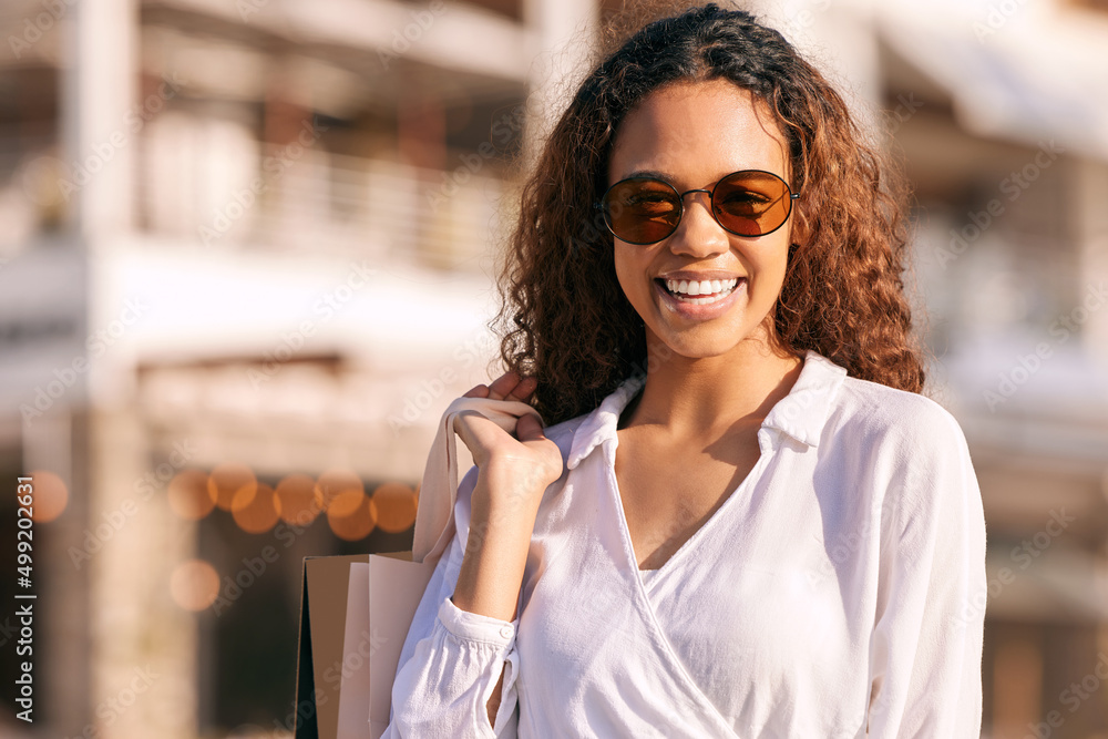 Its time for some retail therapy. Shot of an attractive young woman standing alone outside while sho