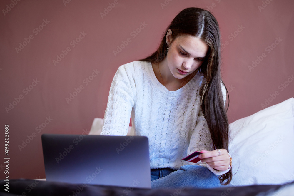 偿还债务从未如此令人满意。一名年轻女子用膝盖在网上购物的照片