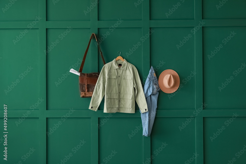 Stylish female clothes hanging on color wall