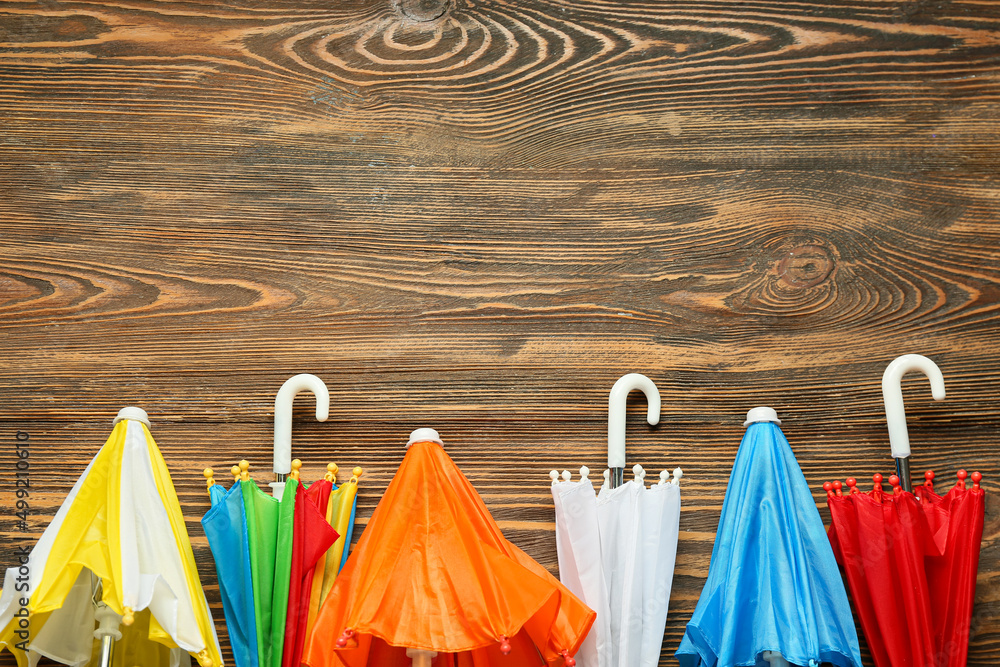 Many different umbrellas on wooden background, closeup