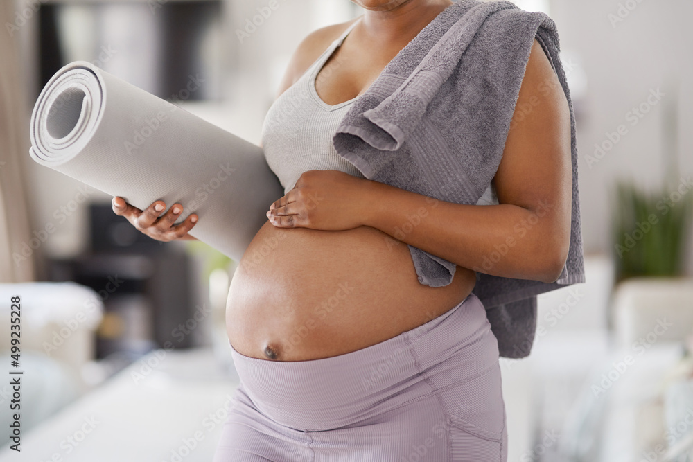 Were ready for some time on the mat. Cropped shot of a pregnant woman posing with a yoga mat and a t