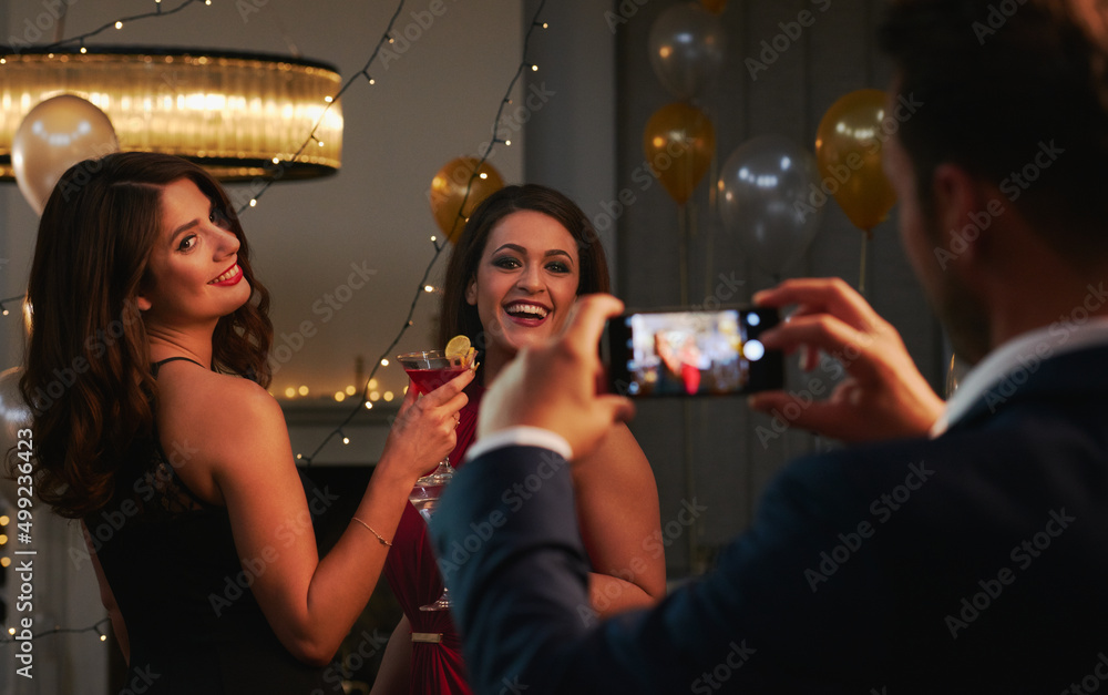 Capturing the moment. Cropped shot of an unrecognizable man taking a photograph of two attractive yo