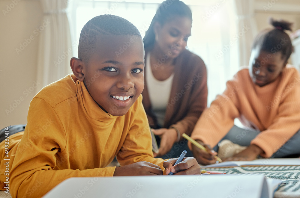 I love not having to go to school. Shot of a young boy completing his homework while his mom helps h