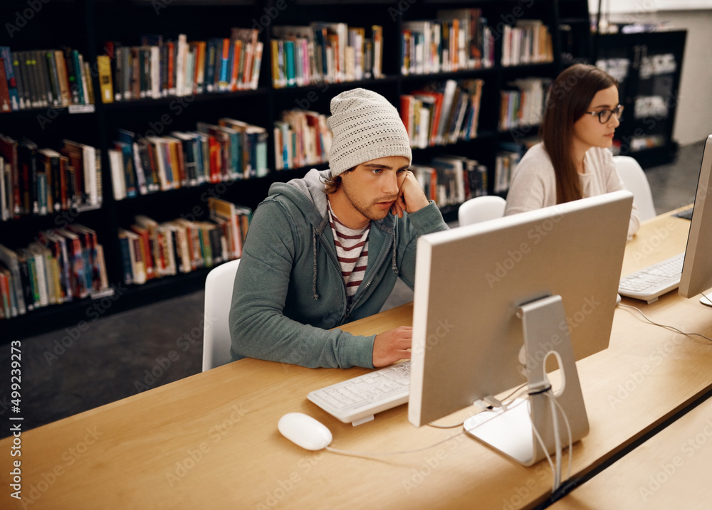 Its exam time. High angle shot of two young university students studying in the library.