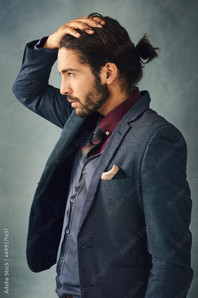 Style from the head down. Studio shot of a stylishly dressed handsome young man standing with his ha