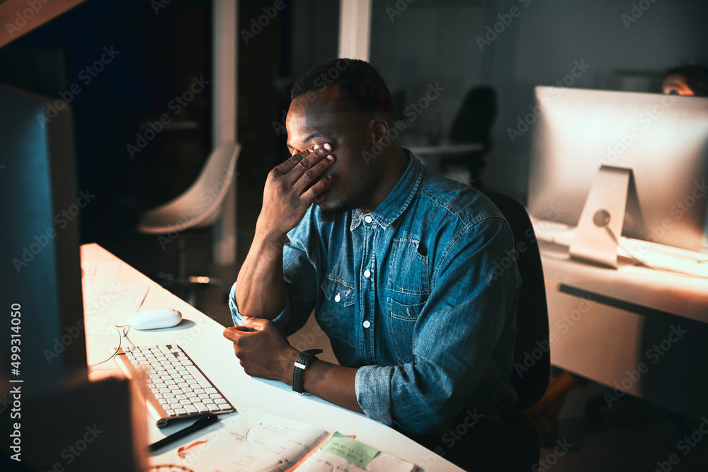 Feeling pressured by the deadline. High angle shot of a young male designer looking stressed while w