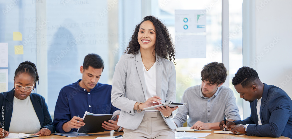 Were all working on a big plan for success. Portrait of a young businesswoman using a digital tablet